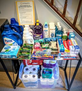 Table full of various household cleaning supplies and personal hygiene items organized by category. 